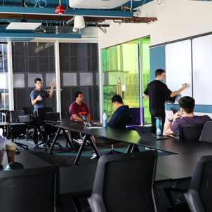 People having a discussion in front of a whiteboard